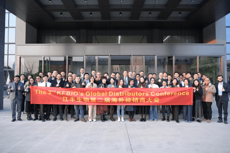 Participants at the First Overseas Distributors Conference pose for a group photograph outside the head office.